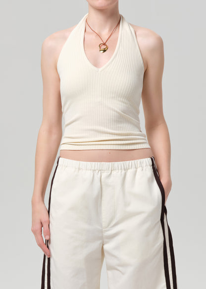 Person wearing a cream-colored halter top and shorts on a light gray background