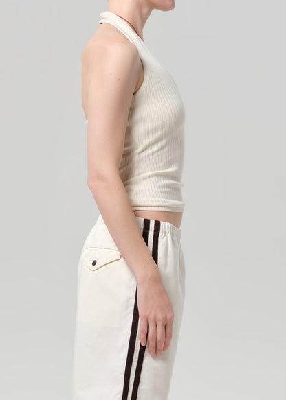 Person wearing a white sleeveless top and white shorts with black stripes on a light gray background