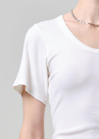 Person wearing a white tee and blue jeans on a plain background