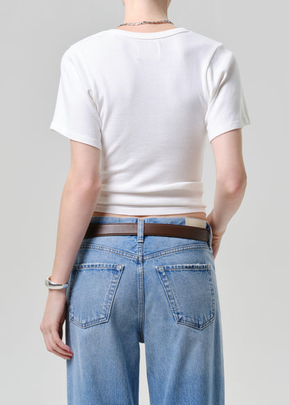Person wearing a white tee and blue jeans on a plain background