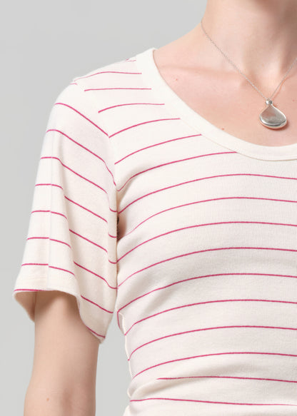 White t-shirt with red stripes worn by a person on a gray background
