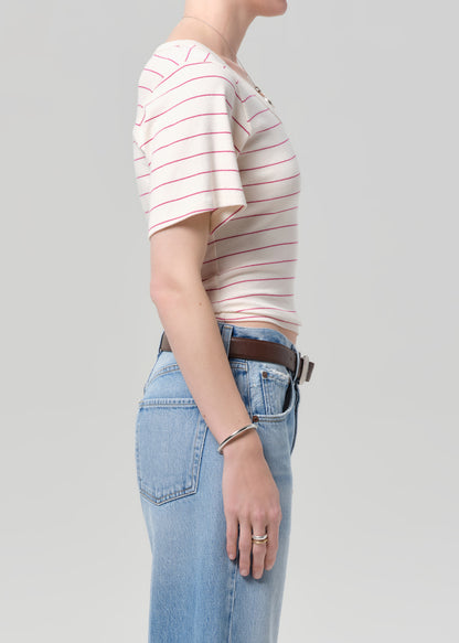 Person wearing a striped shirt and jeans on a plain background