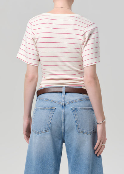 Person wearing a striped shirt and blue jeans on a gray background