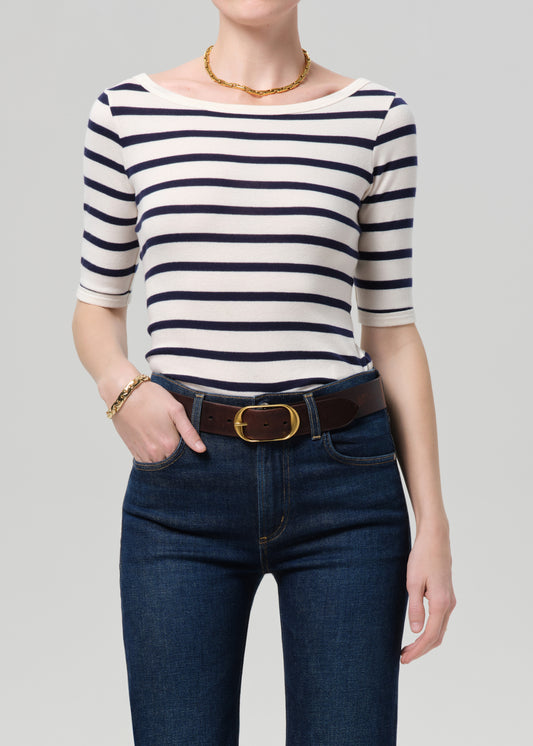 Person wearing a striped shirt and jeans on a gray background