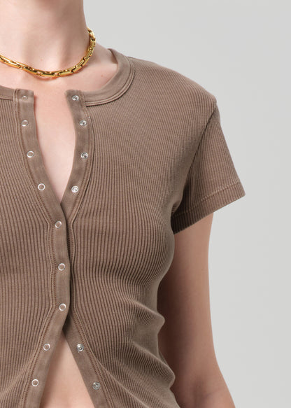 Brown ribbed top with button details on a plain background