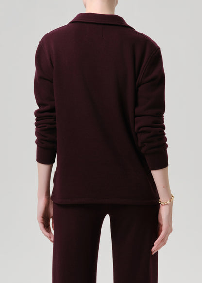 Person wearing a dark brown outfit on a grey background