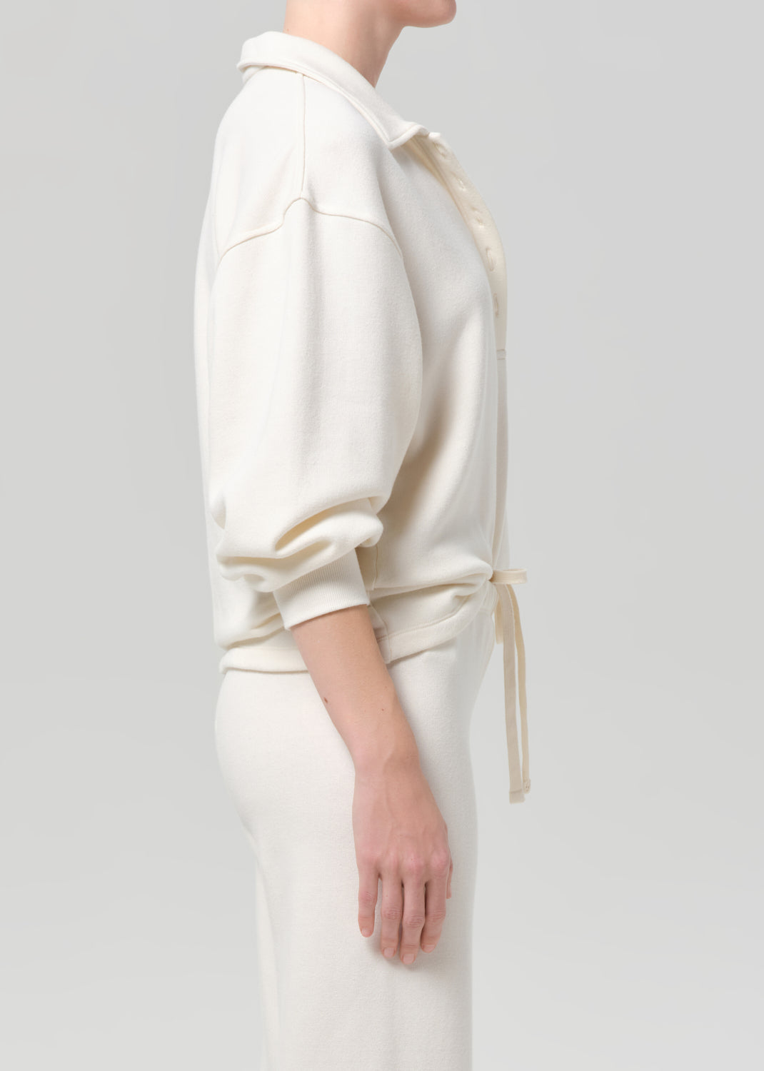 Person wearing a white outfit with a plain background