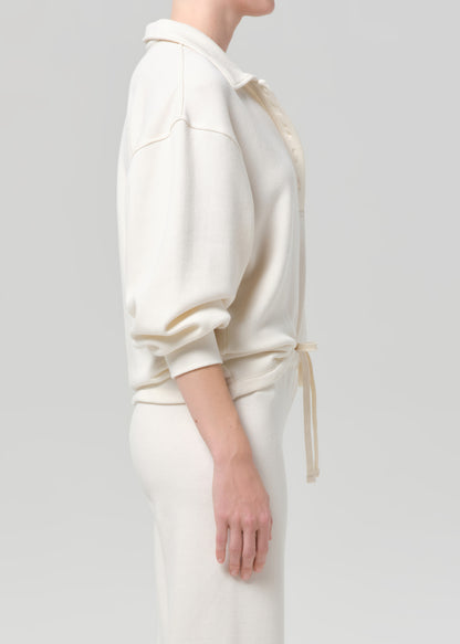 Person wearing a white outfit with a plain background