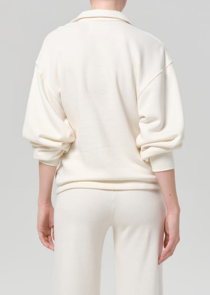 Person wearing a cream-colored outfit on a plain background
