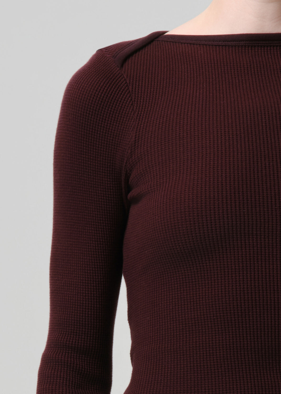 Purple brown ribbed sweater on a grey background