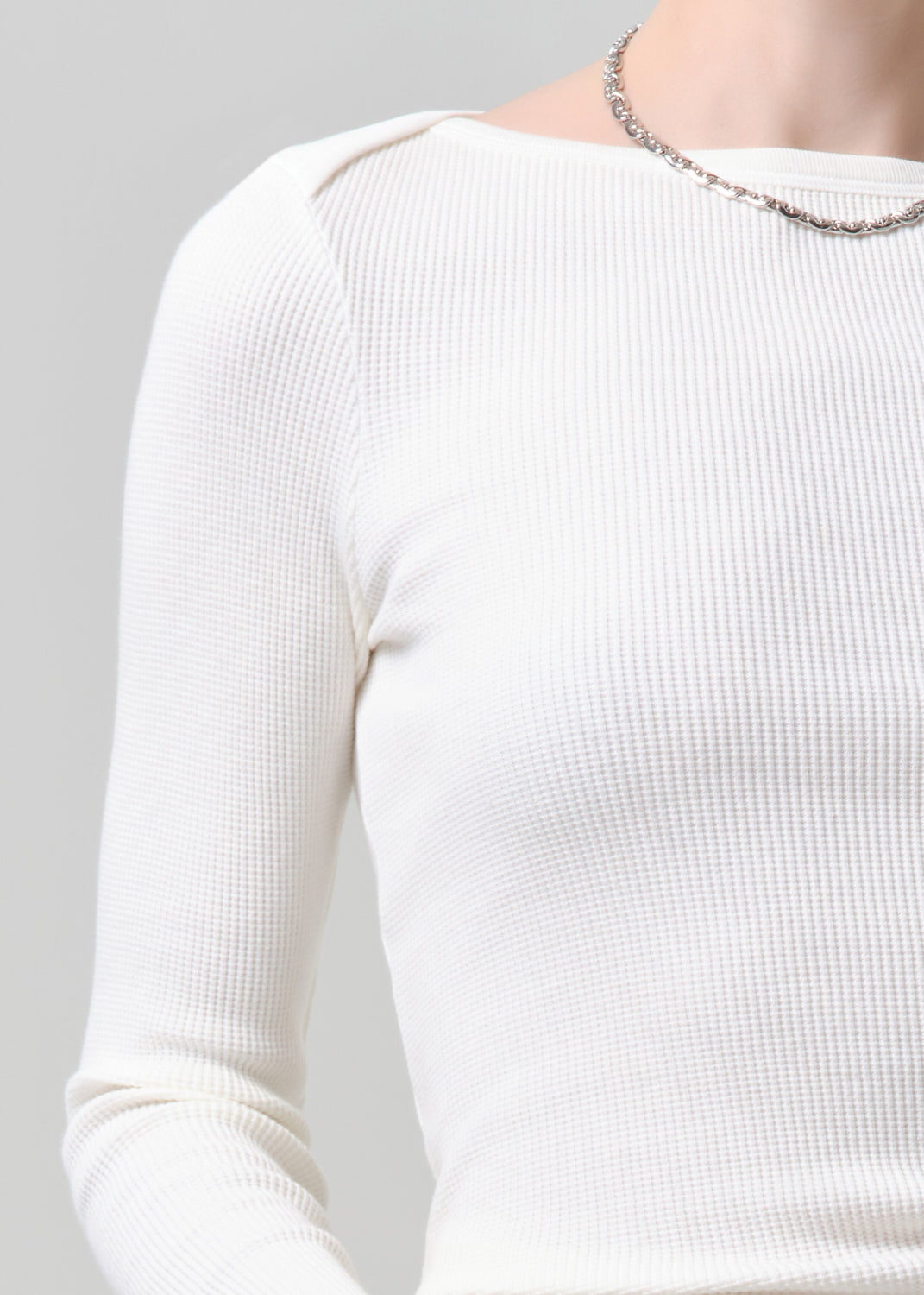 White ribbed sweater on a grey background