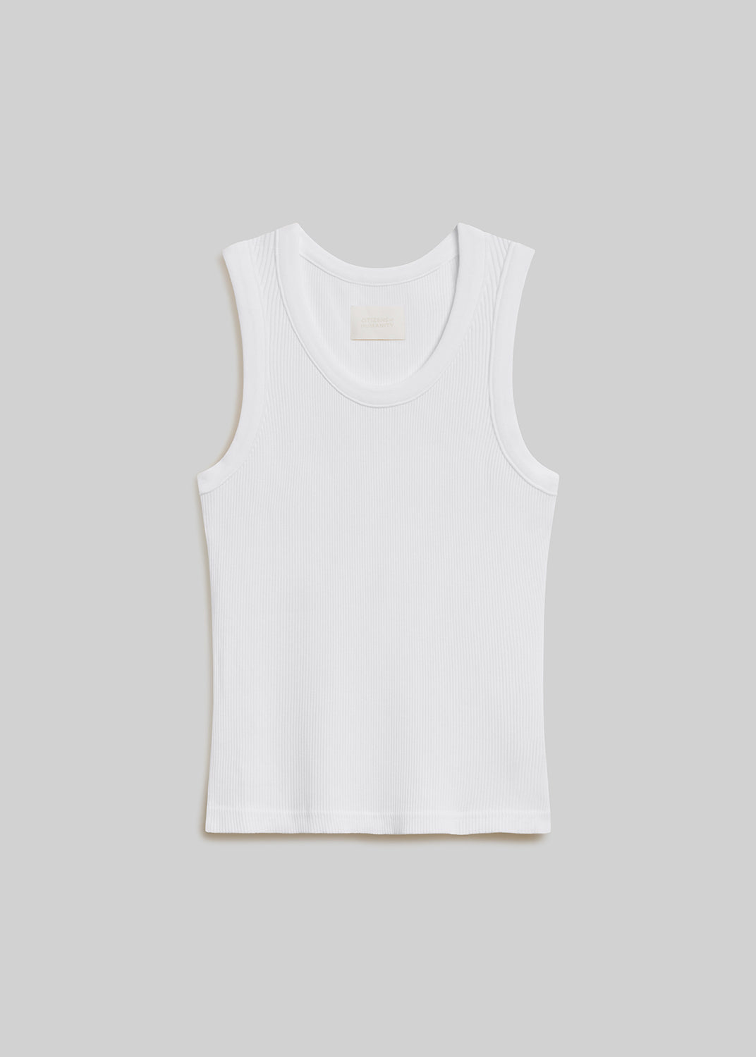 White ribbed knit tank top with a scoop neckline, wide shoulder straps, sleeveless design, and fitted silhouette, front flat lay view on a grey background.