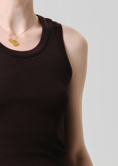 Person wearing a brown tank top on a grey background