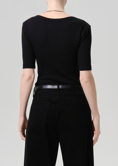 Person wearing a black outfit with a grey background