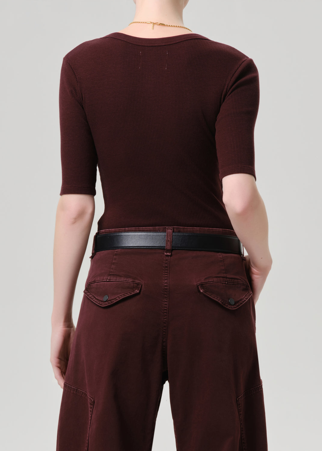 Person wearing a maroon outfit with a grey background