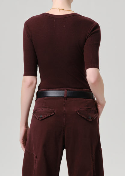 Person wearing a maroon outfit with a grey background