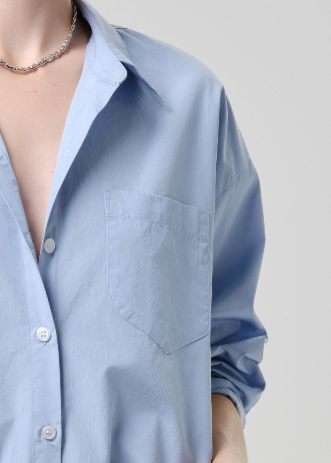 Light blue shirt with a deep neckline on a grey background