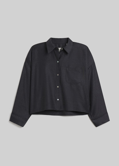 Person wearing heather grey button-down shirt on grey background