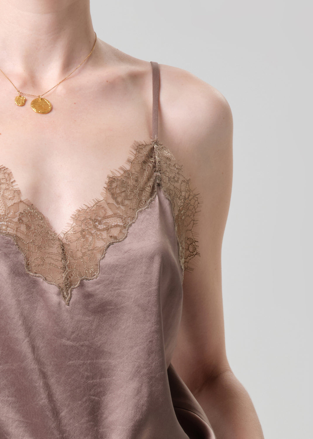 Brown lace-trimmed satin slip on a grey background