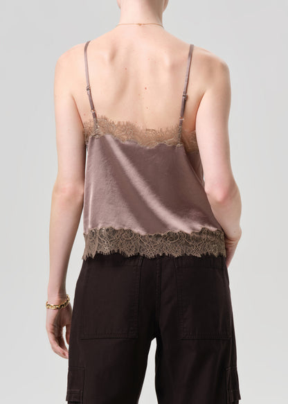 Person wearing a lace-trimmed tank top and cargo pants on a grey background