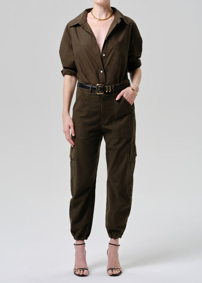 Person wearing a brown jumpsuit on a grey background