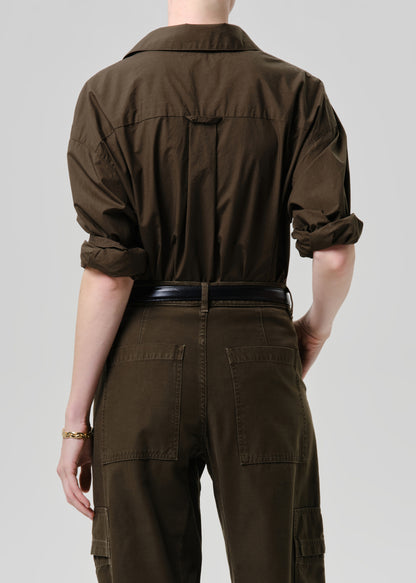 Person wearing a brown jumpsuit on a grey background