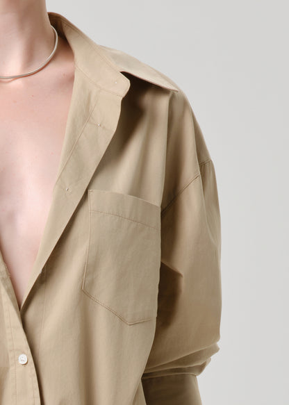 Beige shirt with a deep neckline on a grey background