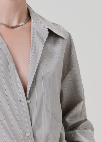 Close-up of a light grey striped button front blouse on a grey background
