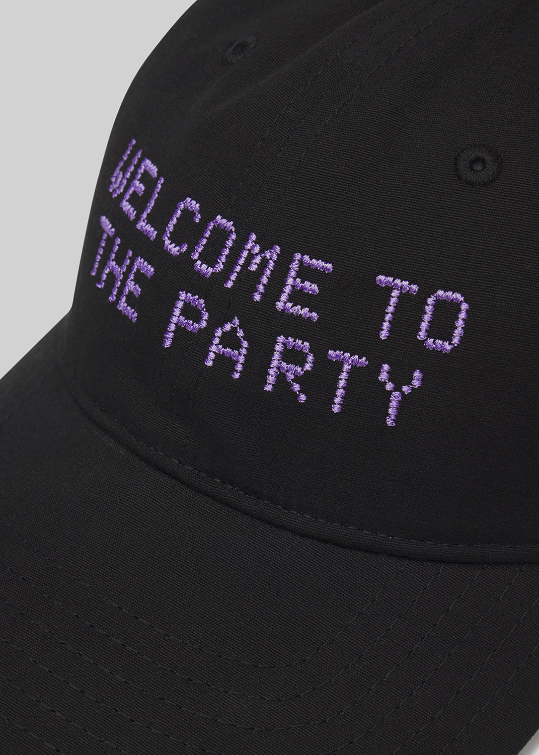 Black cap with 'WELCOME TO THE PARTY' text in purple on a gray background