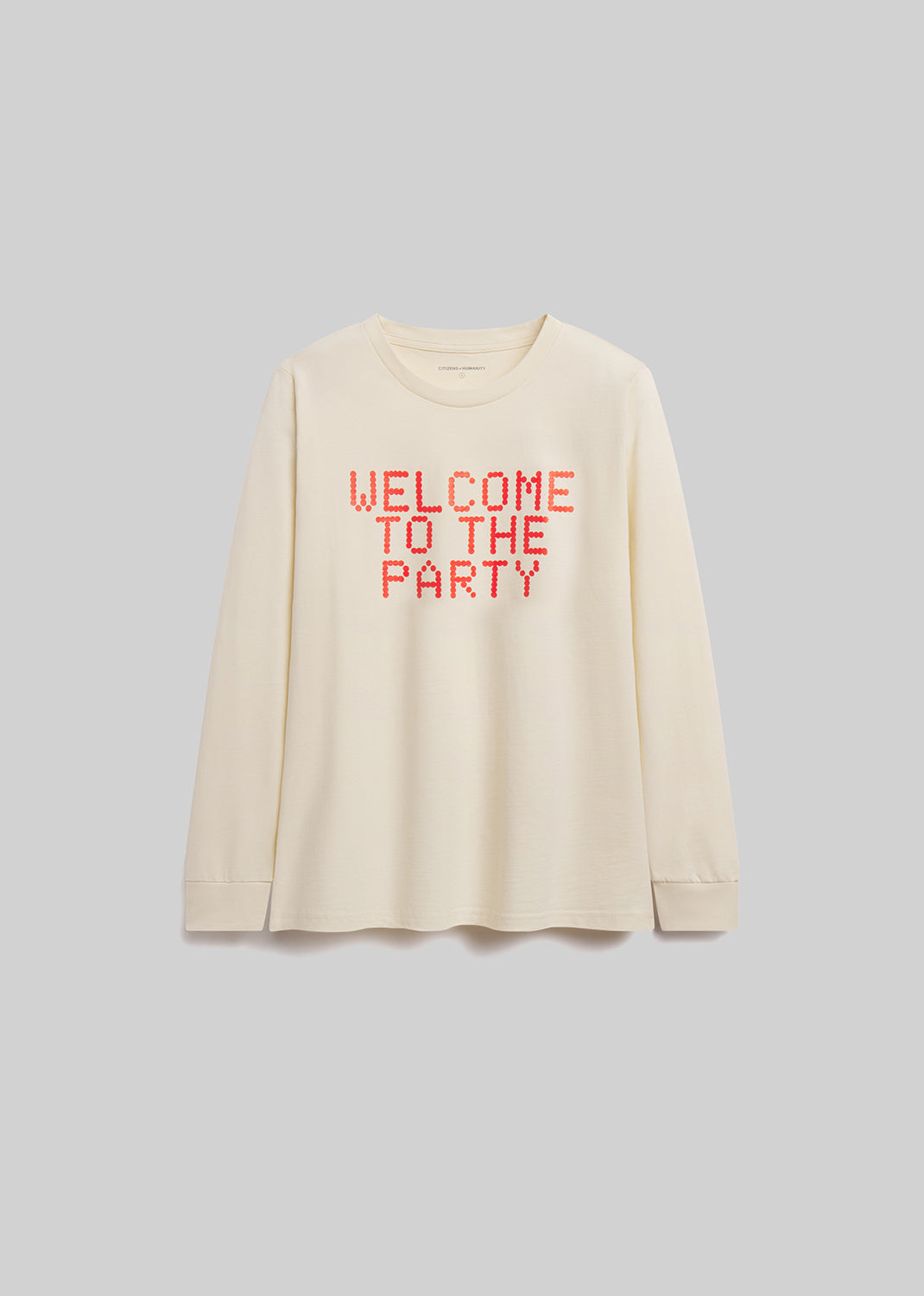 Beige long-sleeve shirt with 'WELCOME TO THE PARTY' text in red on a gray background