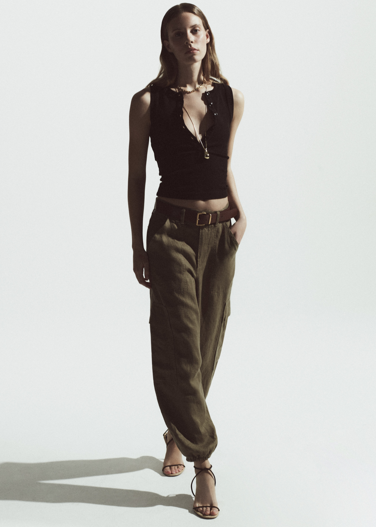 Person wearing a chocolate tank with olive green linen pants