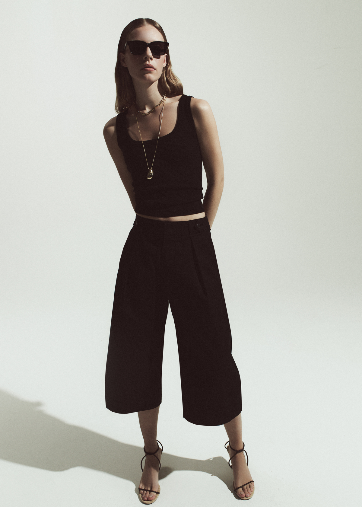 Person wearing a black tank with black Culotte pants