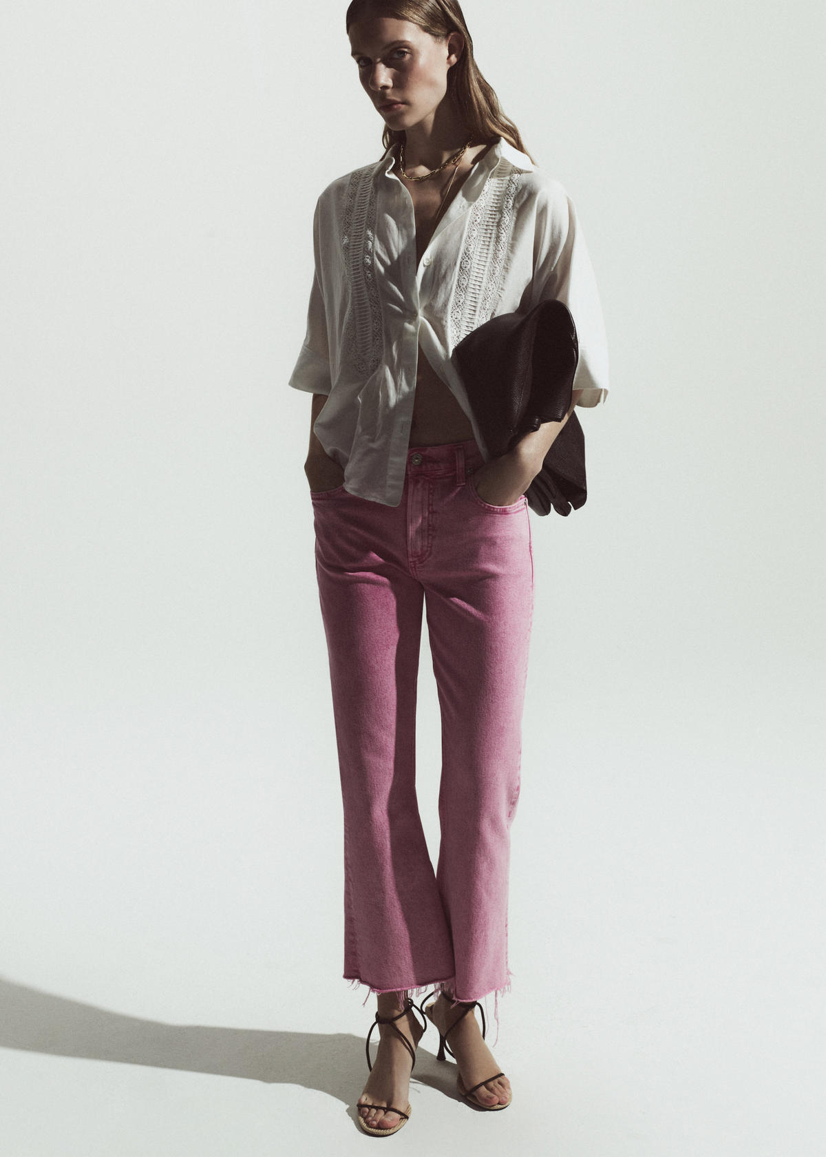 Person wearing a white blouse with pink jeans