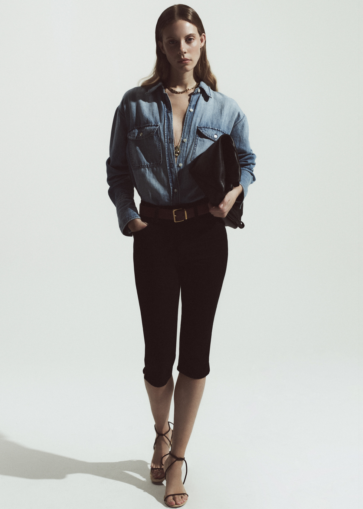 Person wearing a denim shirt with black capris