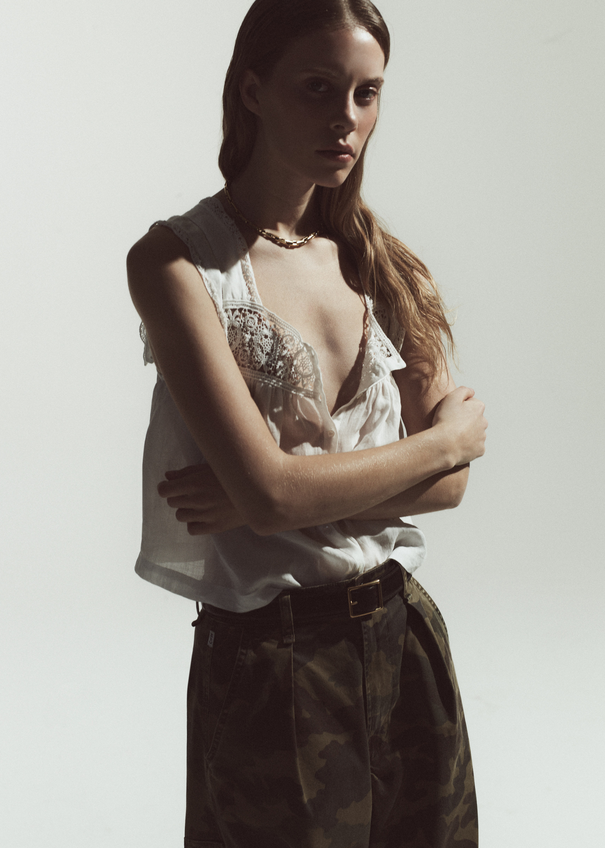 Person wearing a white tank with camo utility pants