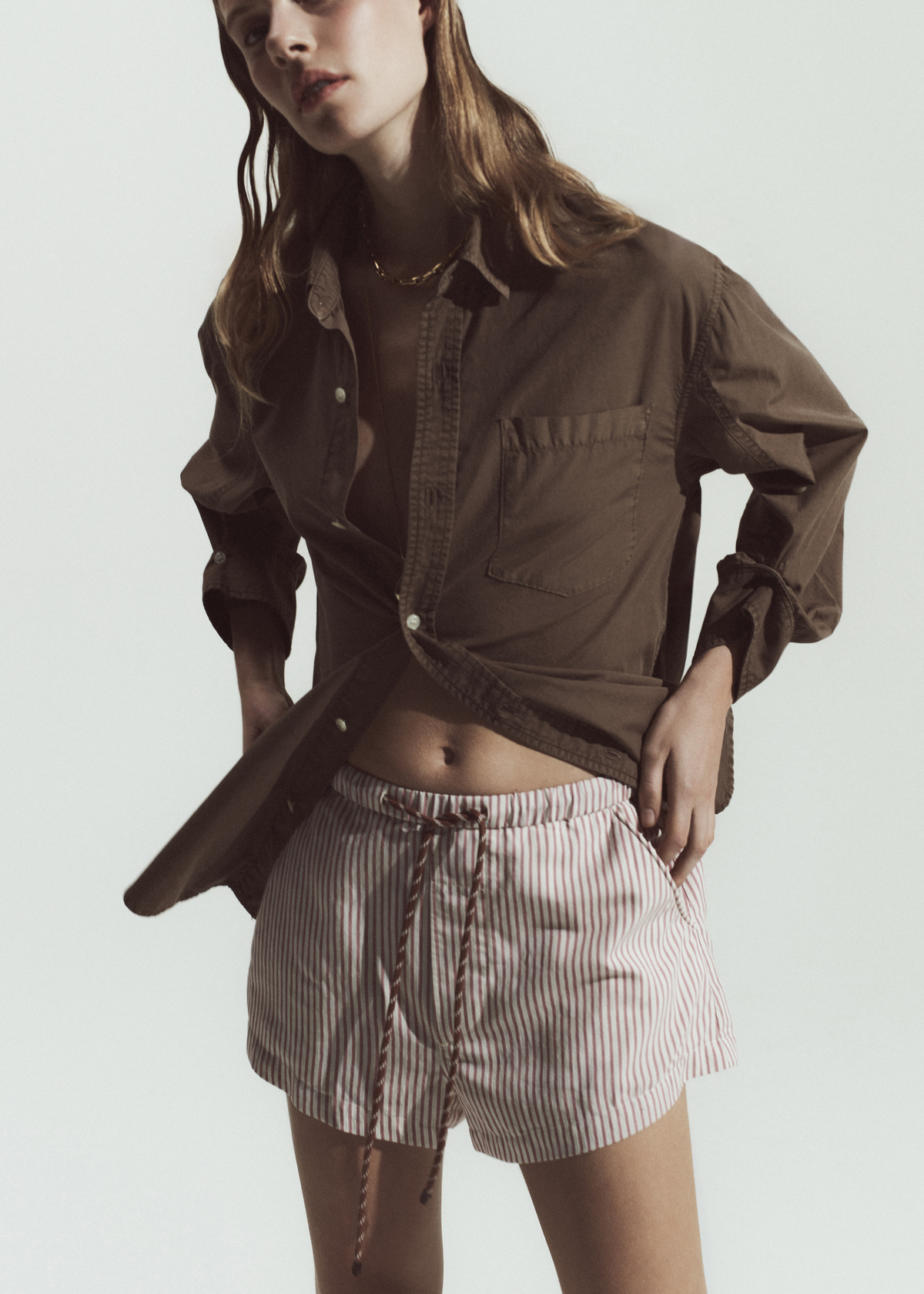 Women wearing a brow shirt paired with drawstring short with pink stripe