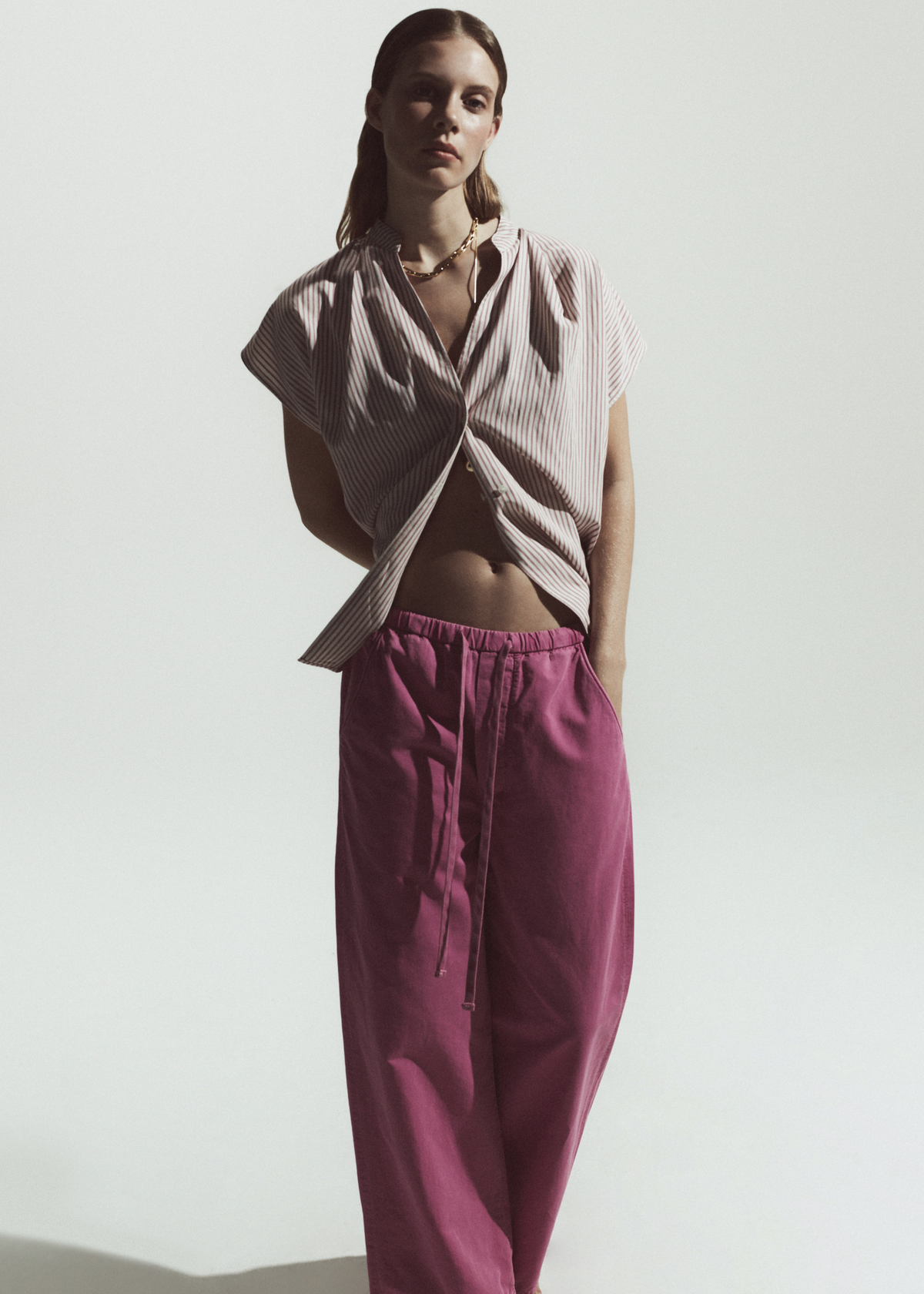 Person wearing blouse with pink stripe paired with pink pants 