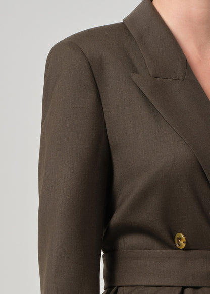 Brown blazer with a gold button on a light gray background