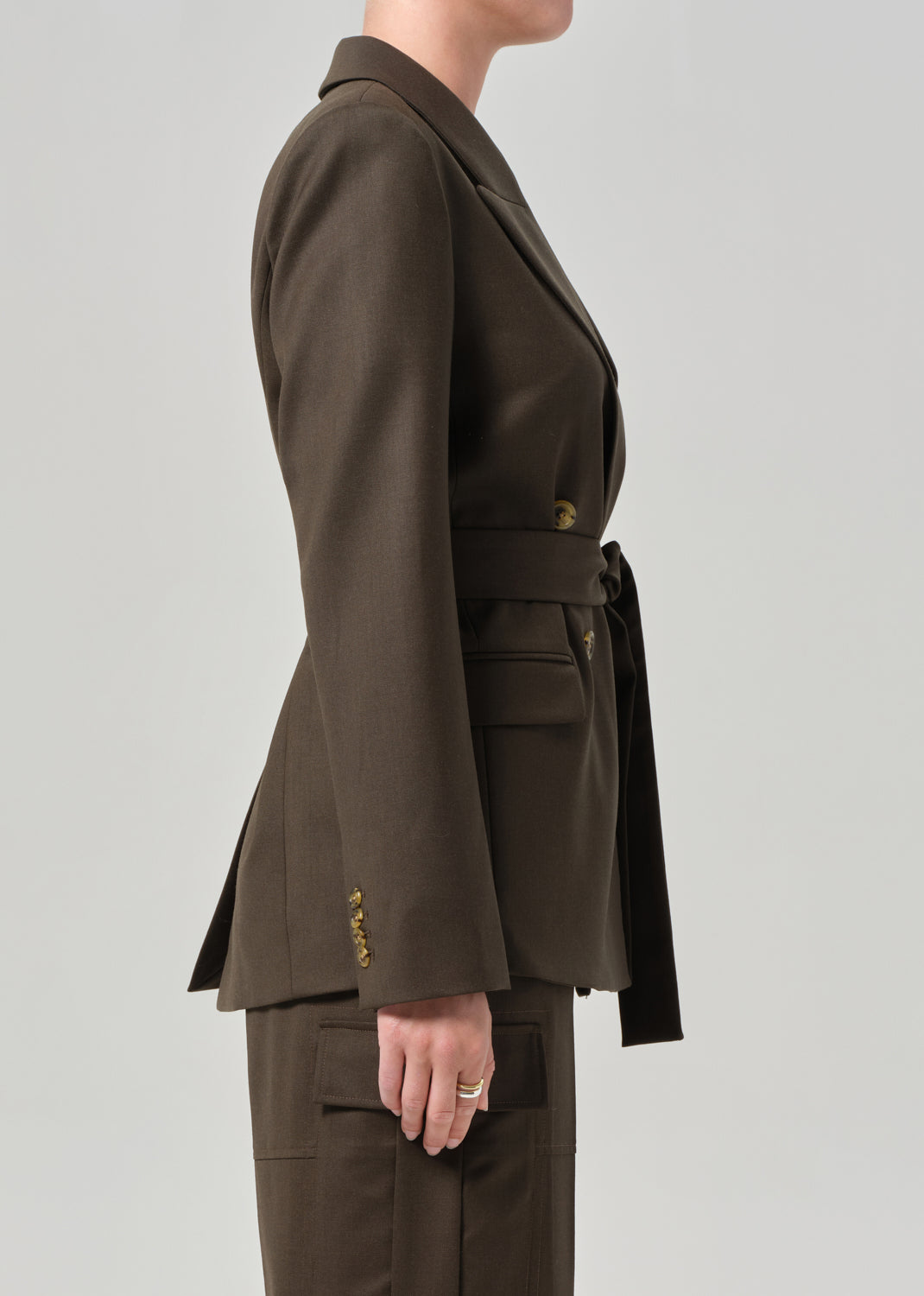 Brown suit jacket and pants on a plain background