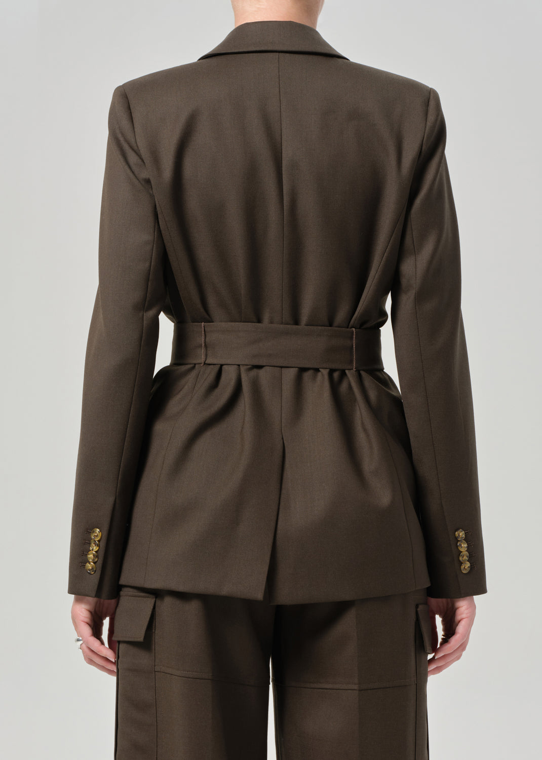 Brown suit with a belt on a plain background