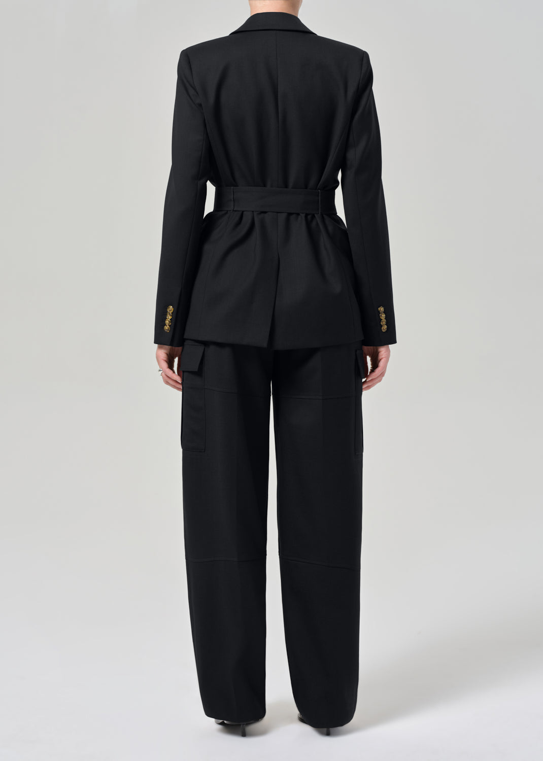 Black suit with gold buttons on a grey background