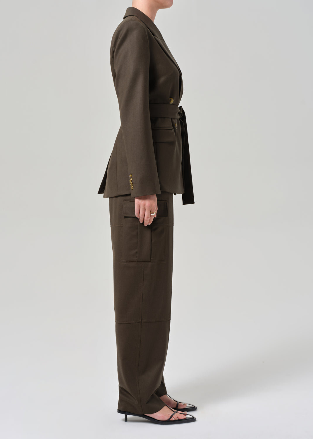 Person wearing a brown suit on a grey background