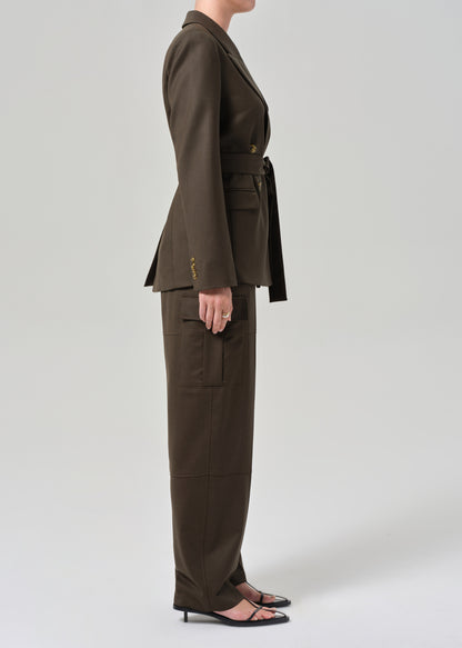 Person wearing a brown suit on a grey background