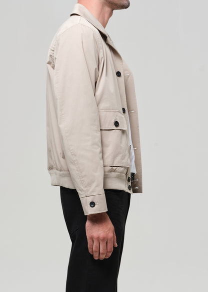 Beige jacket worn by a person on a light gray background