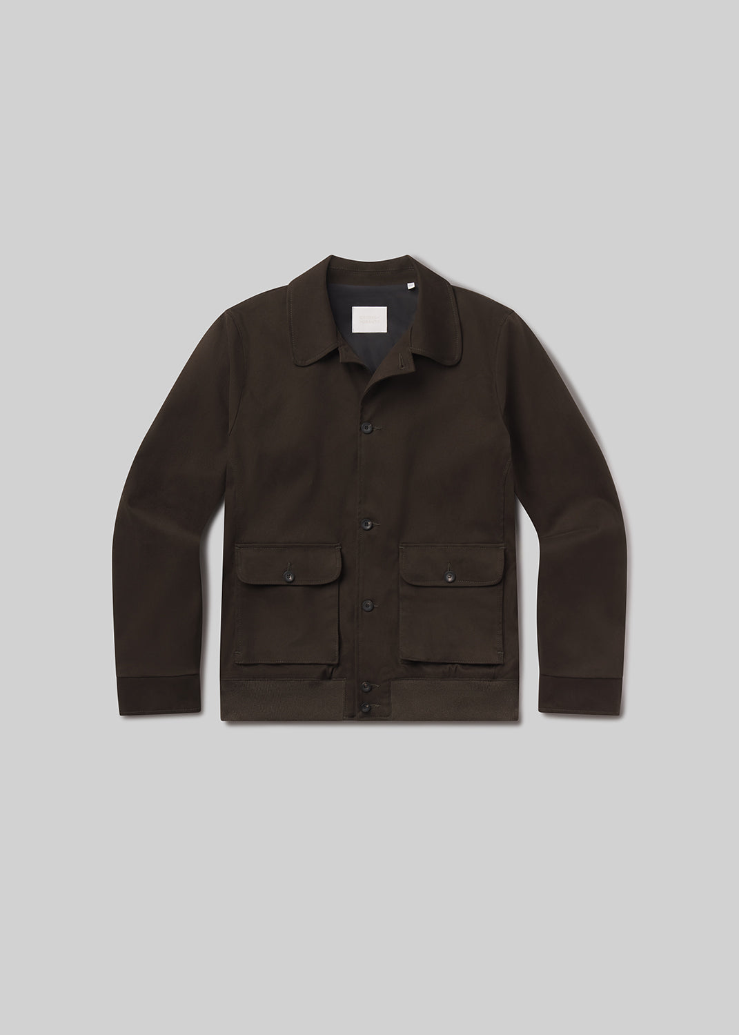 Flat lay shot of olive jacket on a grey background