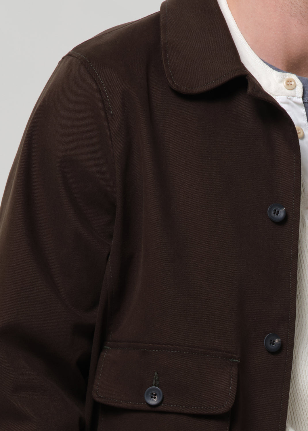 Close-up of a olive jacket with buttons on a grey background