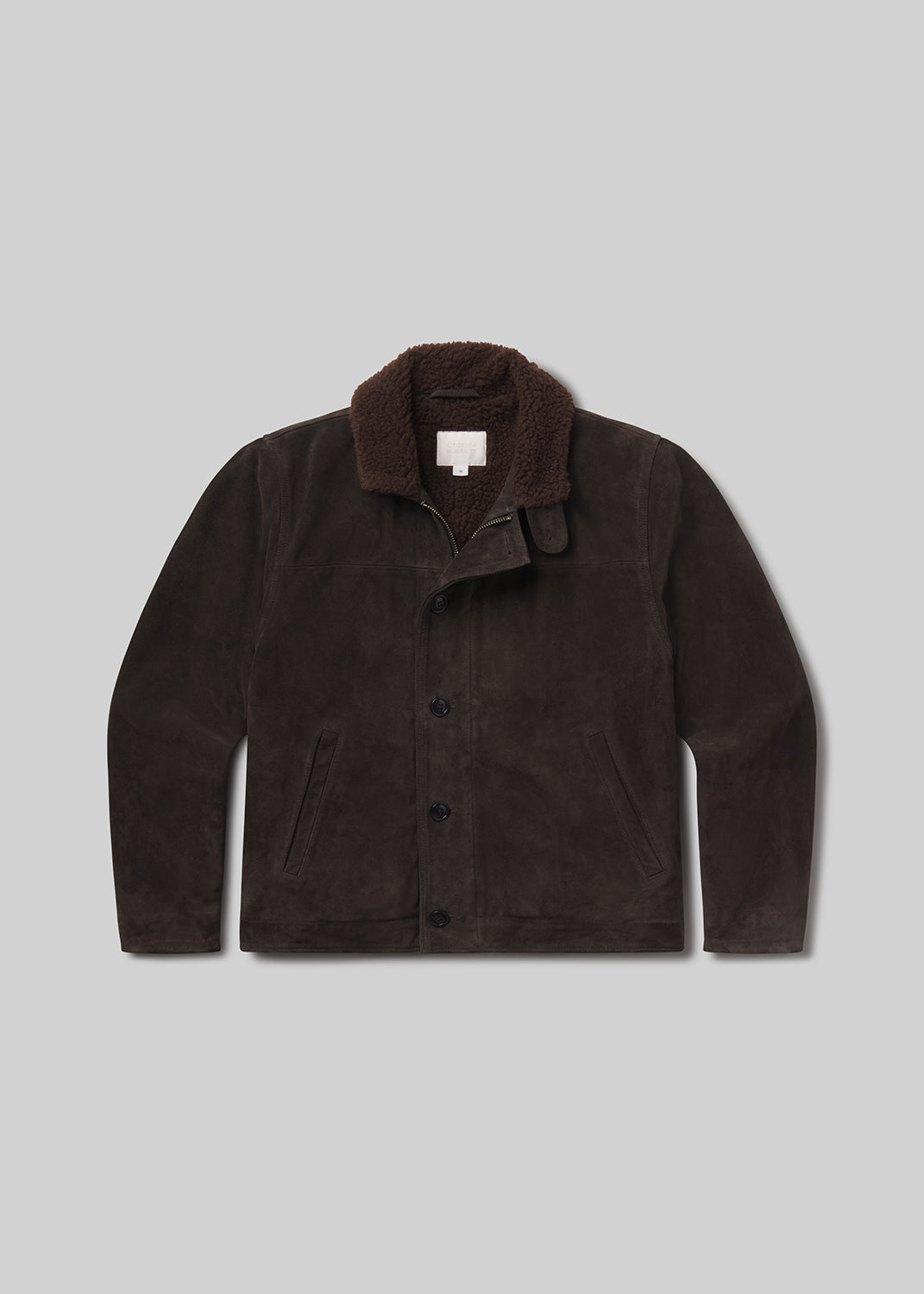 Flat lay shot of brown jacket with a fur collar on a grey background