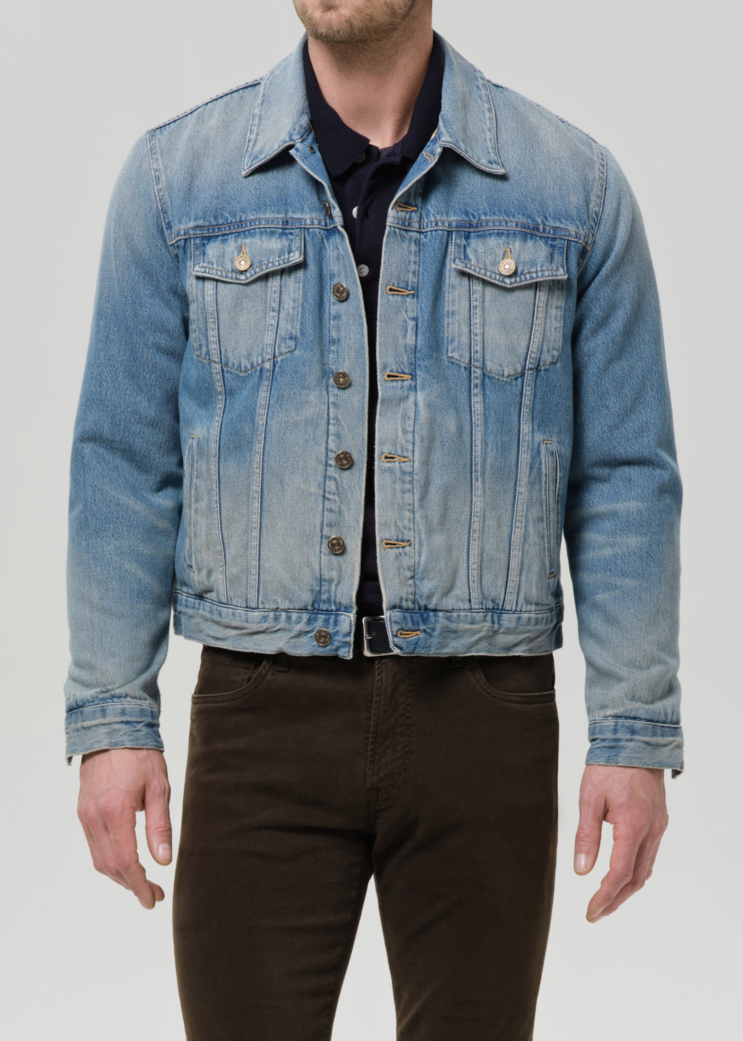 Denim jacket worn by a person on a grey background