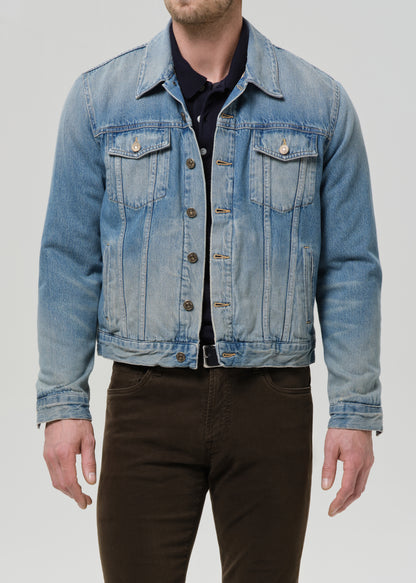 Denim jacket worn by a person on a grey background