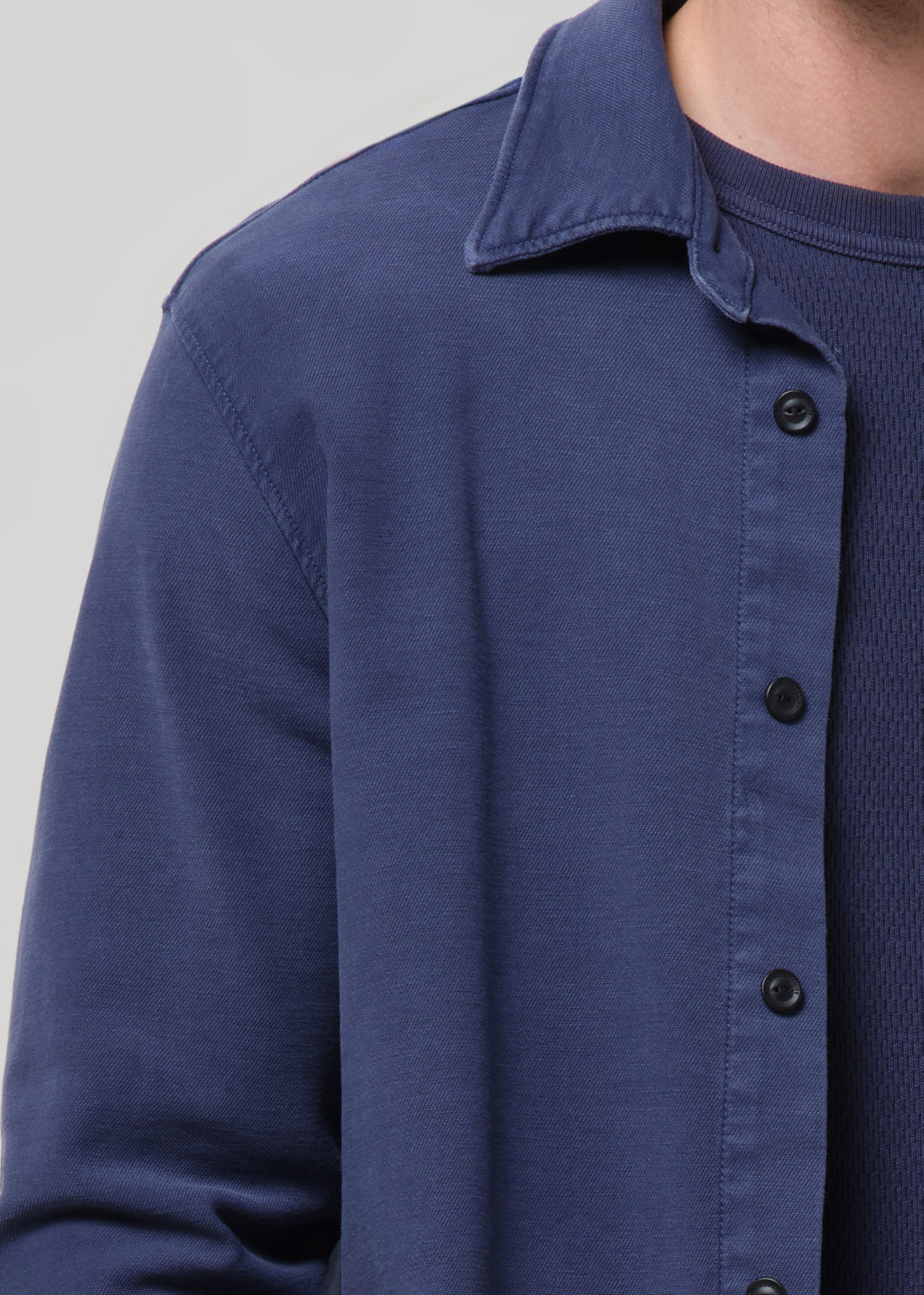Close-up of a blue button-up shirt on a grey background